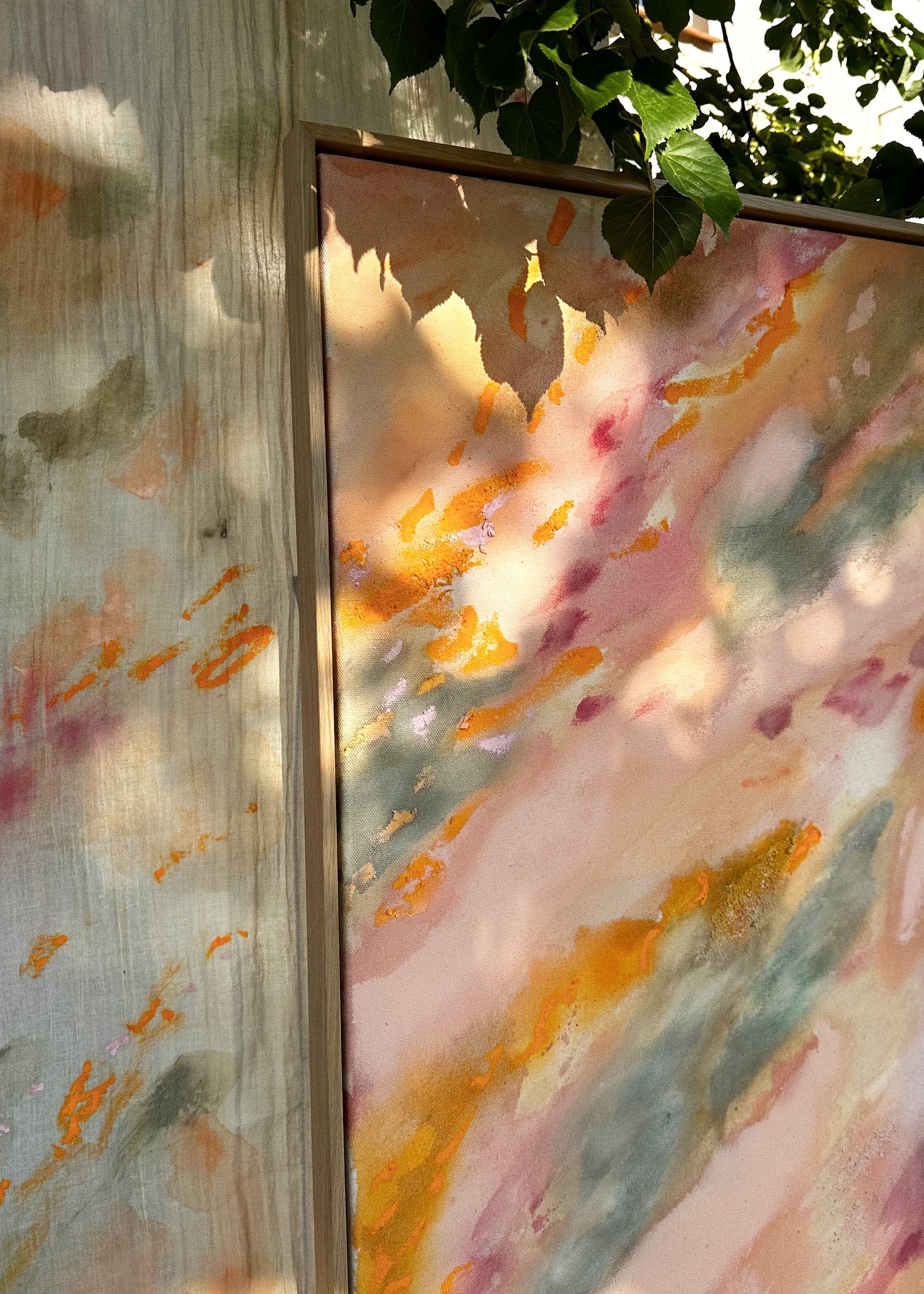 Abstrakt artwork featuring swirling patterns in pink, orange, and pastel tones in green and orange on a textured surface framed in oak wood.