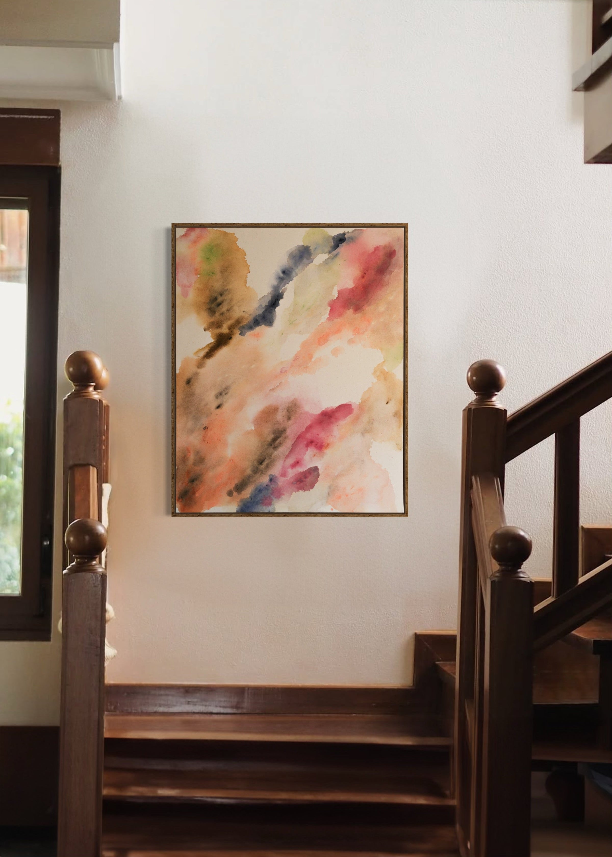 Abstract watercolor in earthy tones such as beige, rose, orange, and brown, with touches of blue and green. The colors flow transparently into one another on a white background, framed in a slim, wooden frame.