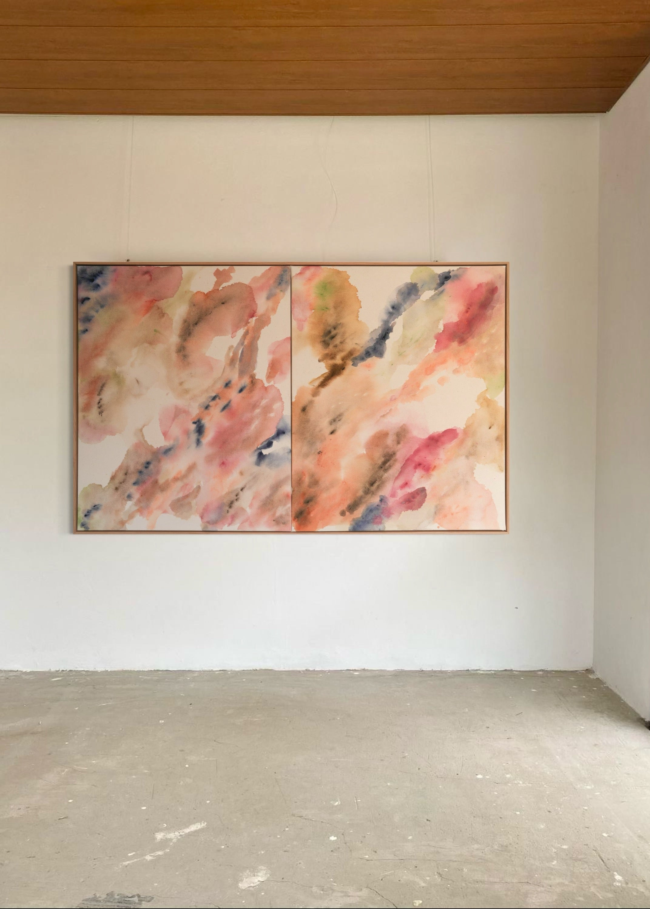 Abstract watercolor in earthy tones such as beige, rose, orange, and brown, with touches of blue and green. The colors flow transparently into one another on a white background, framed in a slim, wooden frame.