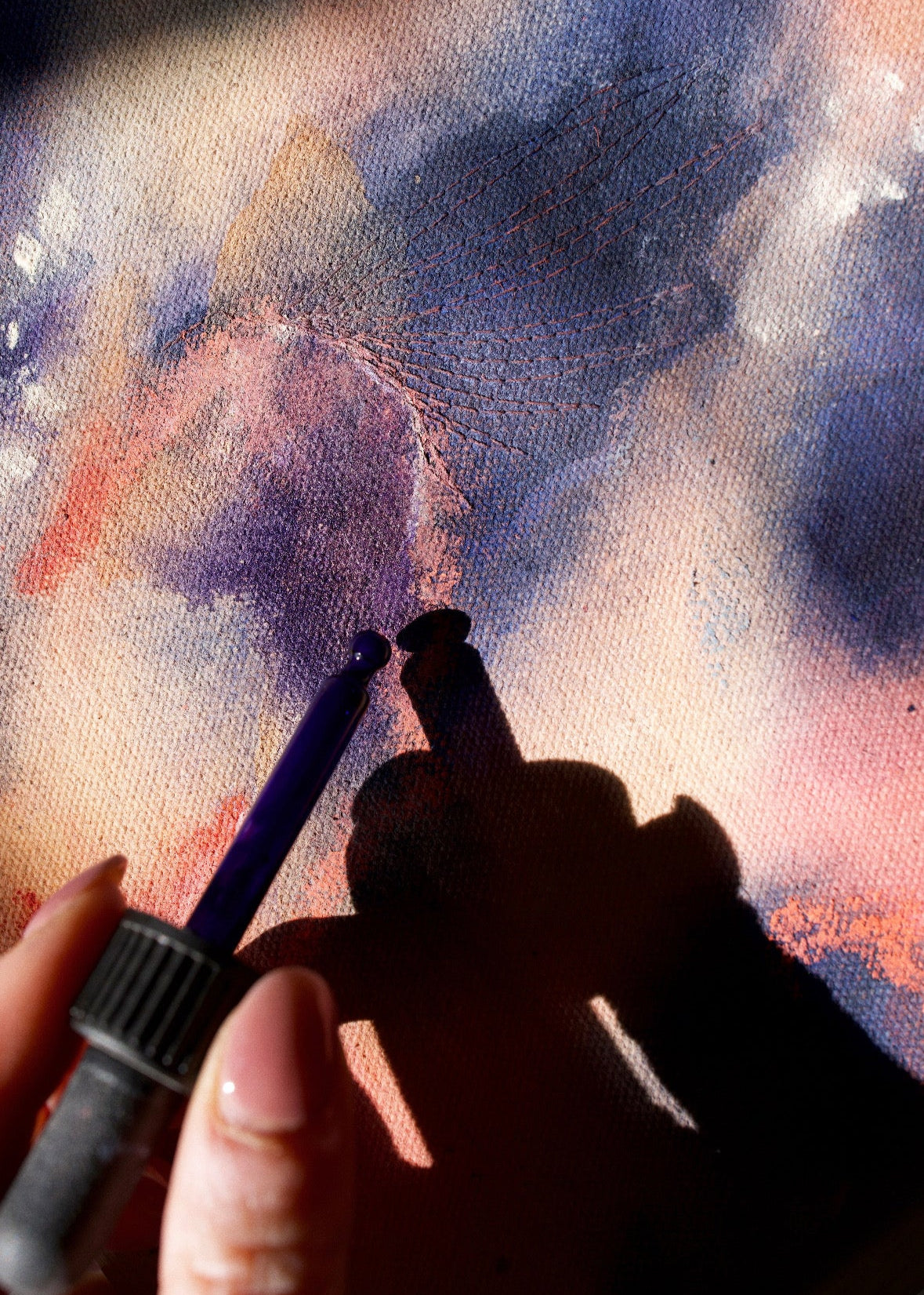 Close Up of an abstract painting with swirling blue and pink tones, framed in wood, evoking motion and emotion.