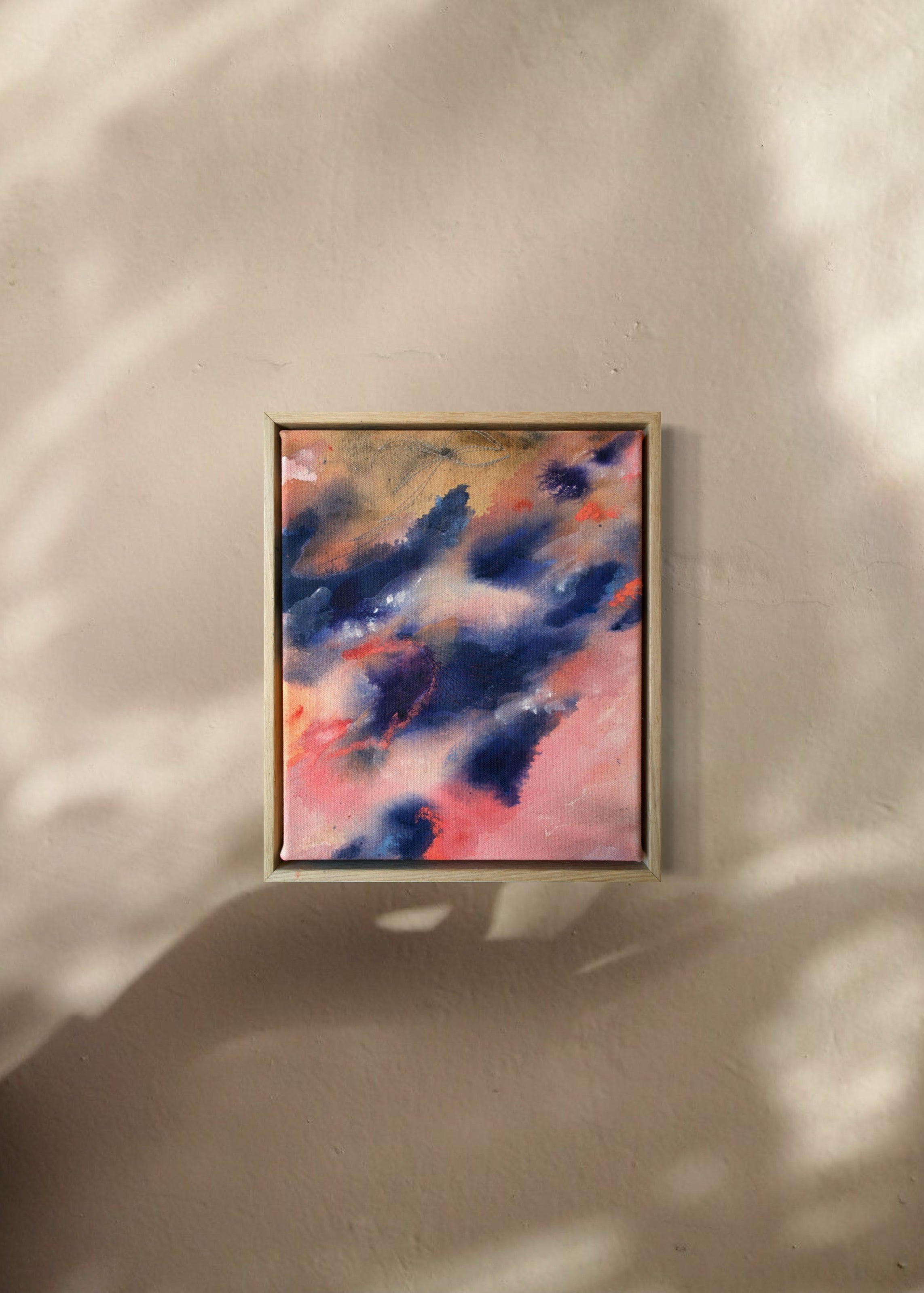 Abstract painting with swirling blue and pink tones, framed in wood, evoking motion and emotion.