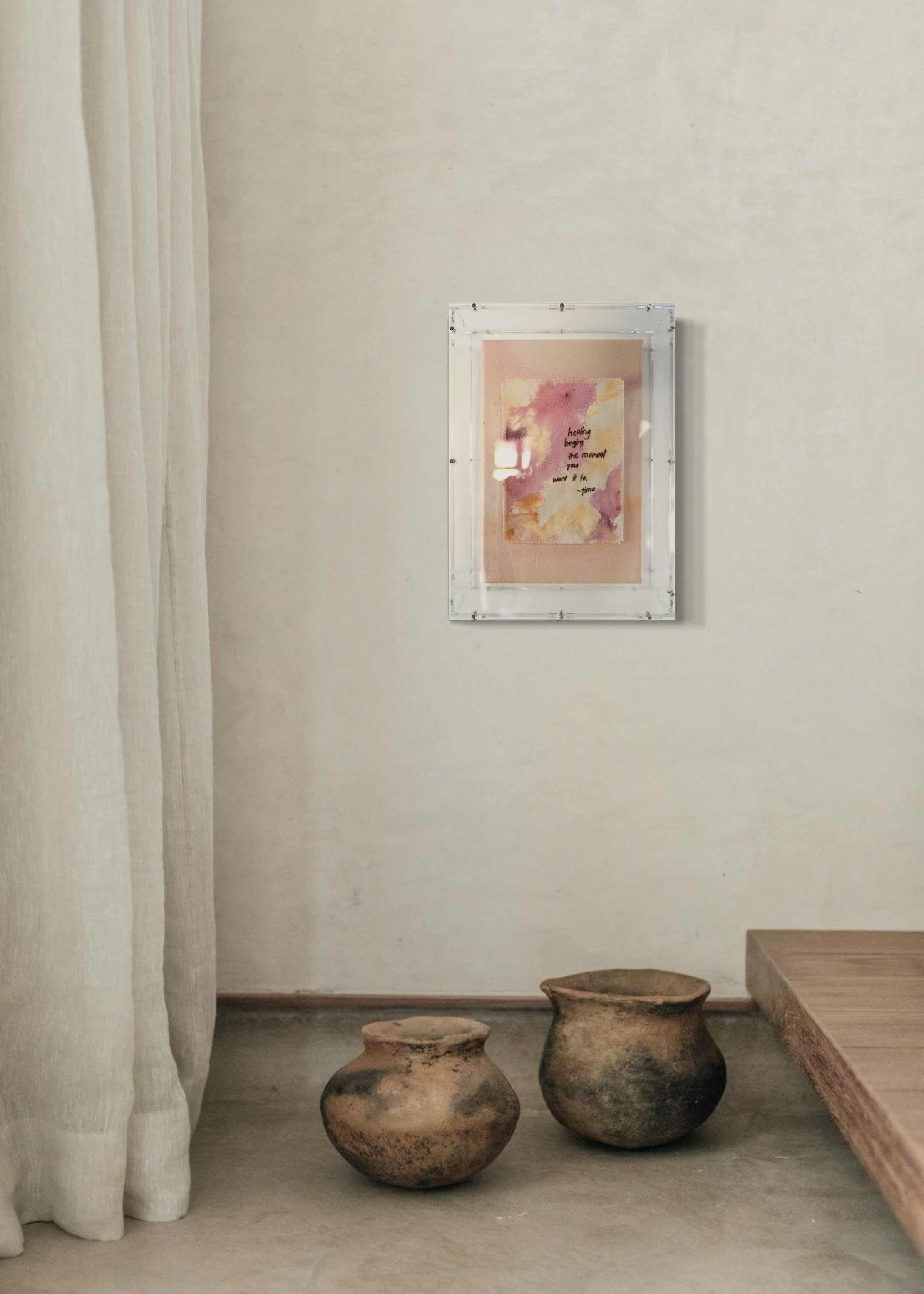 The abstract painting features a soft pink, beige, and orange watercolor background. It has a hand-stitched poem that says, "Healing begins the moment you want it to." This artwork radiates hope and is beautifully framed in clear acrylic.