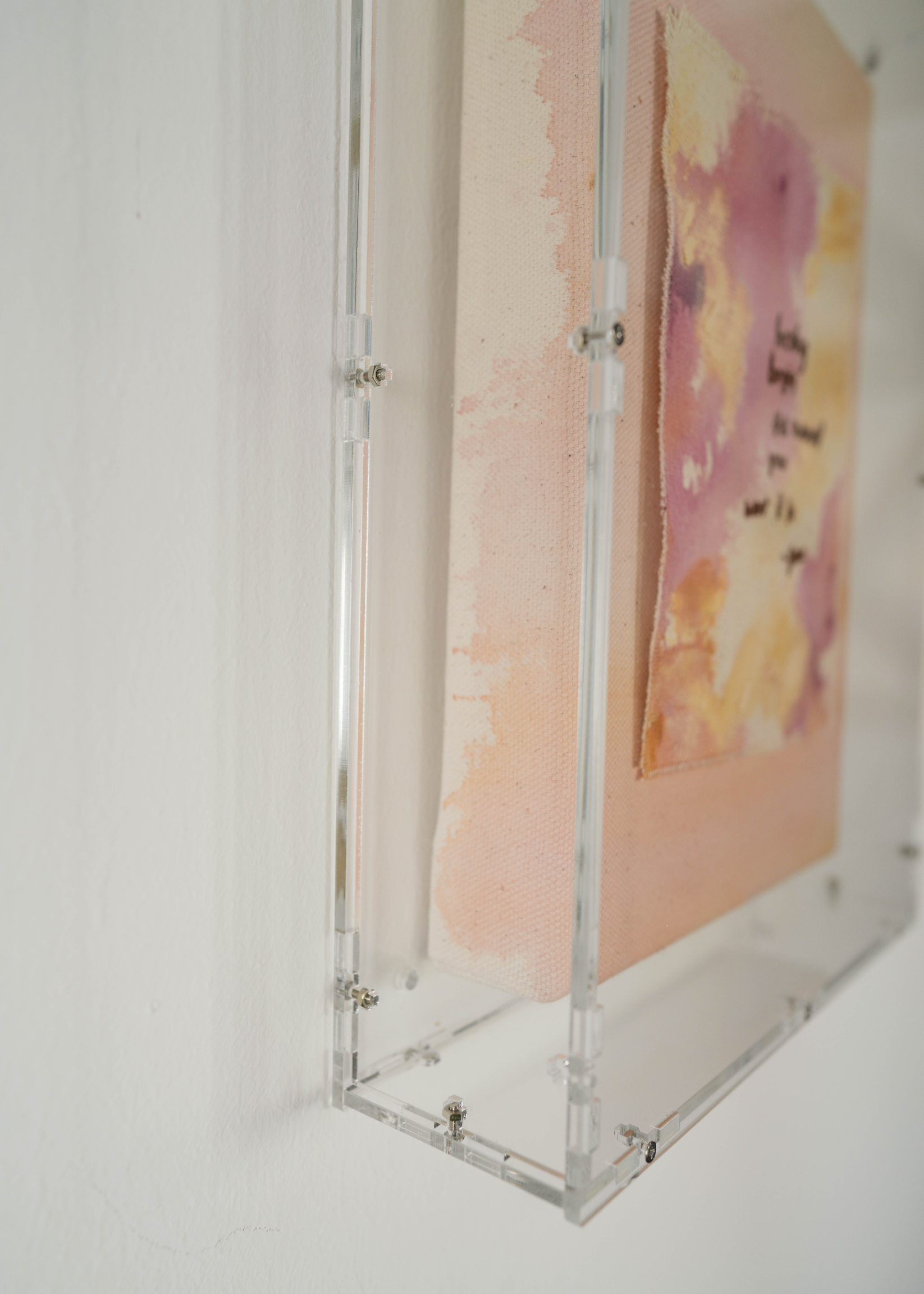 The abstract painting features a soft pink, beige, and orange watercolor background. It has a hand-stitched poem that says, "Healing begins the moment you want it to." This artwork radiates hope and is beautifully framed in clear acrylic.