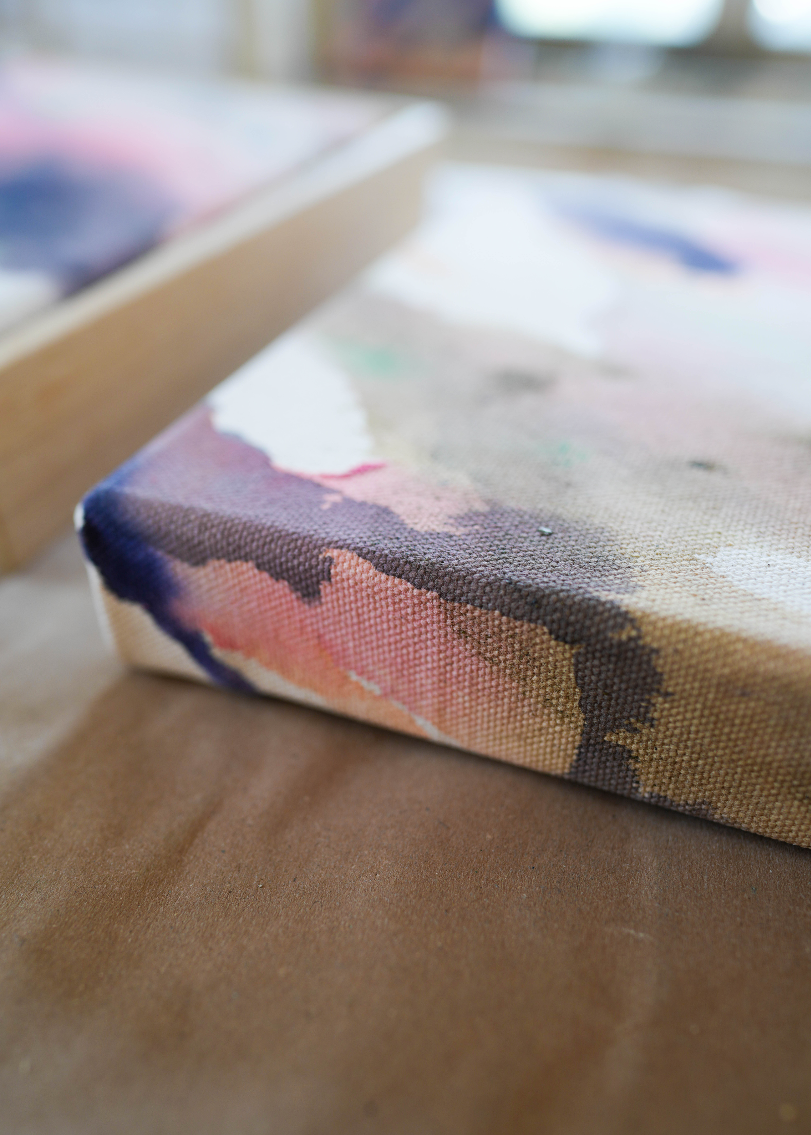 Abstract acrylic painting with soft swirls of pink, purple, and earthy tones, framed in wood. It conveys a serene, dreamy ambiance.