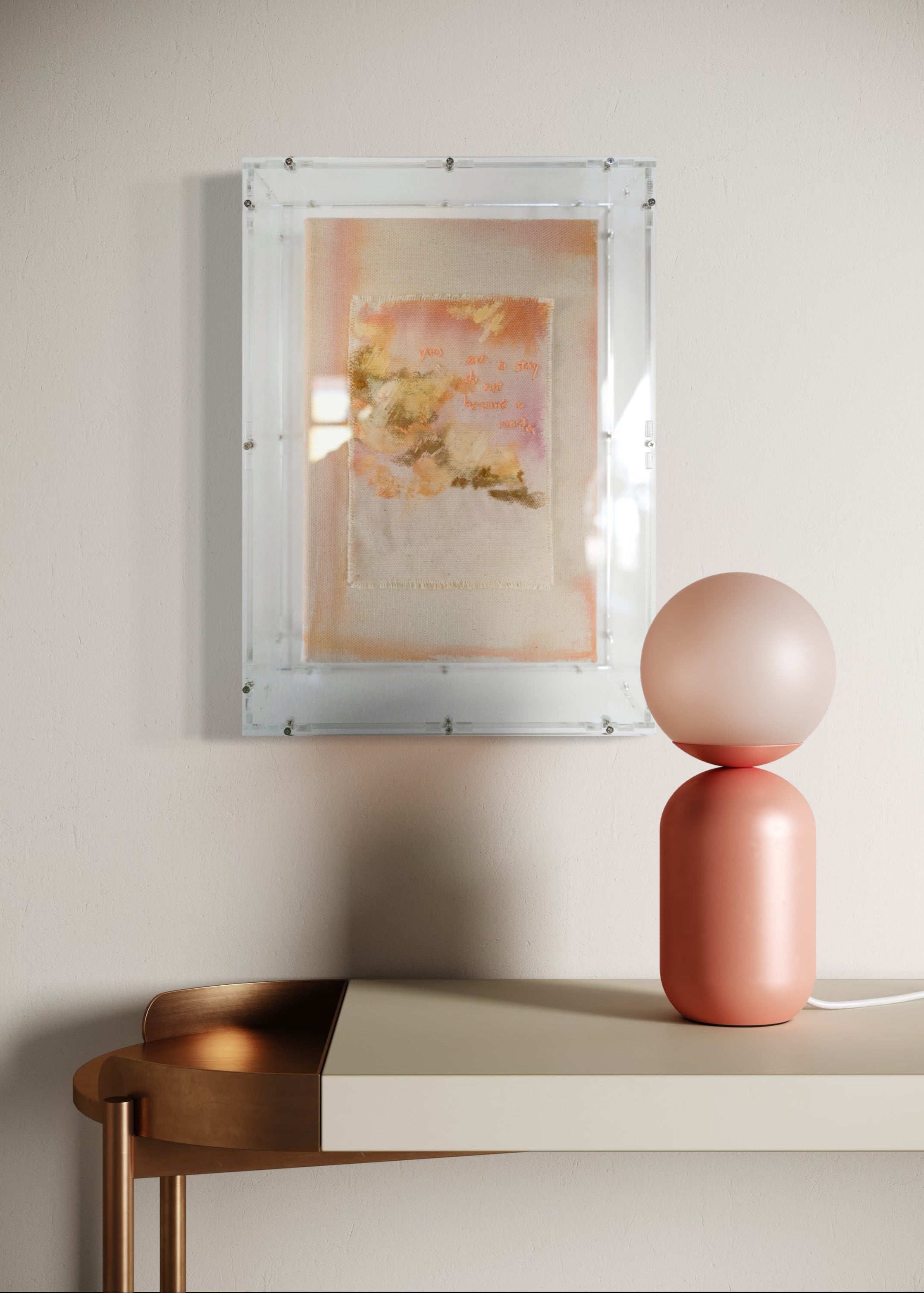 This textured abstract artwork showcases soft pastel shades of pink and orange. It features gentle brushstrokes and embroidered text that reads, "You are a story; do not become a word." The piece is elegantly framed in clear acrylic.