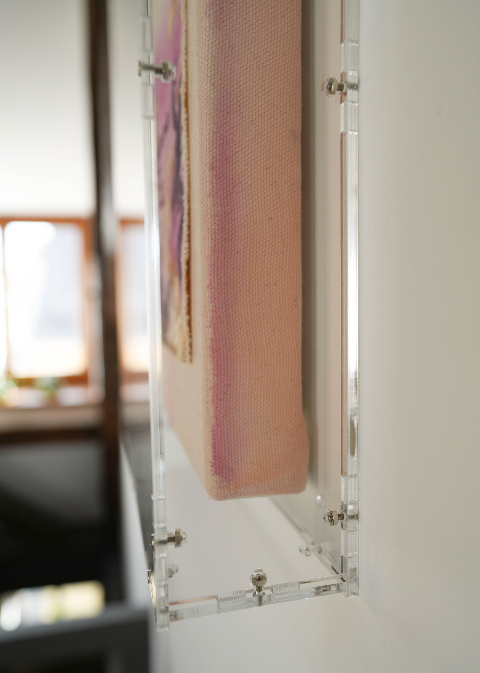 Abstract painting featuring purple, dark purple, and beige brushstrokes on canvas. With a stitched poem that reads, "everything I need already exists in me." Framed in clear acrylic.