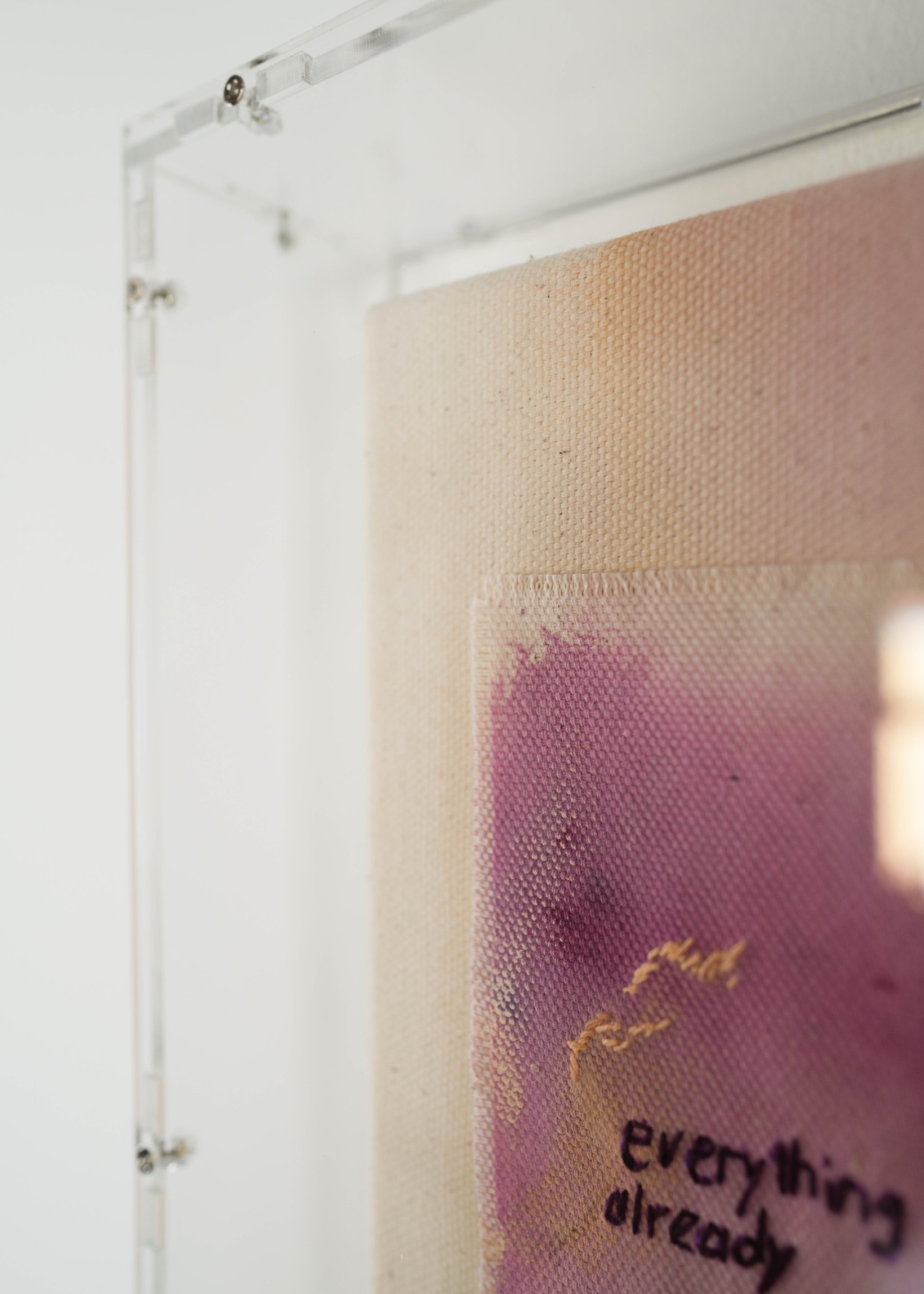 Abstract painting featuring purple, dark purple, and beige brushstrokes on canvas. With a stitched poem that reads, "everything I need already exists in me." Framed in clear acrylic.