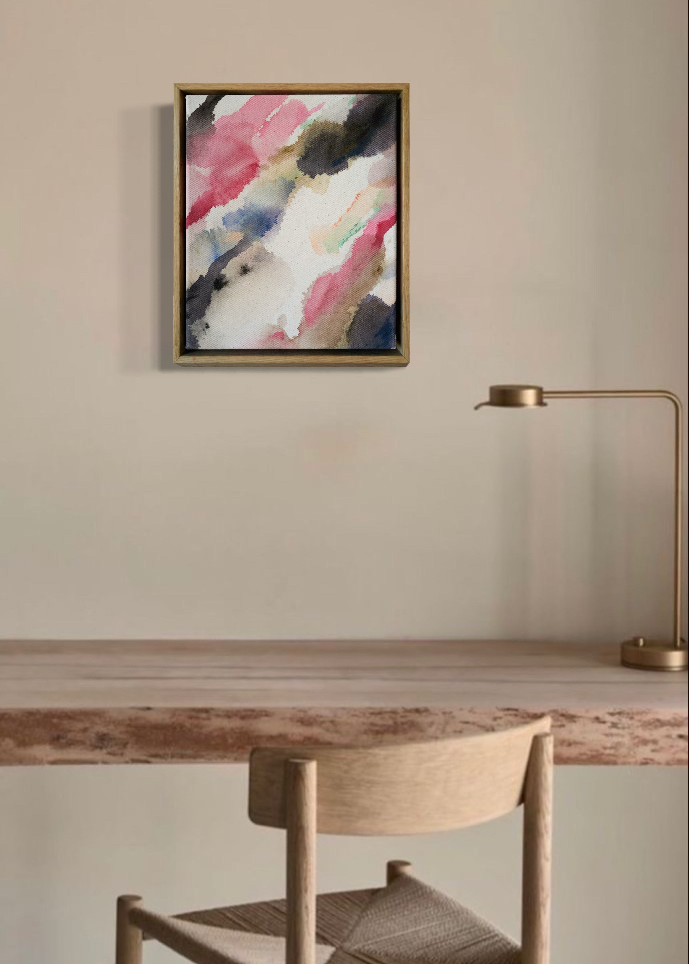 Abstract acrylic watercolor painting in a wooden frame. Soft pink, grey, and brown hues blend on a raw canvas, creating a calm, fluid effect.