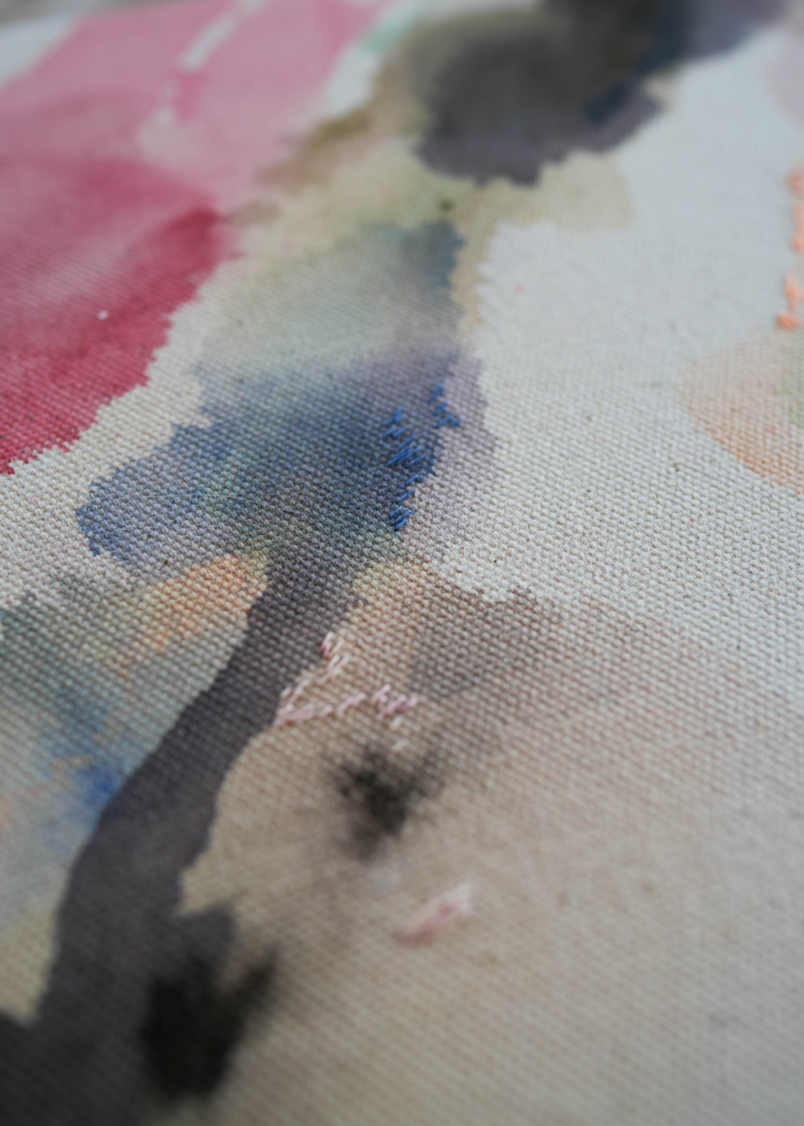 Abstract acrylic watercolor painting in a wooden frame. Soft pink, grey, and brown hues blend on a raw canvas, creating a calm, fluid effect.