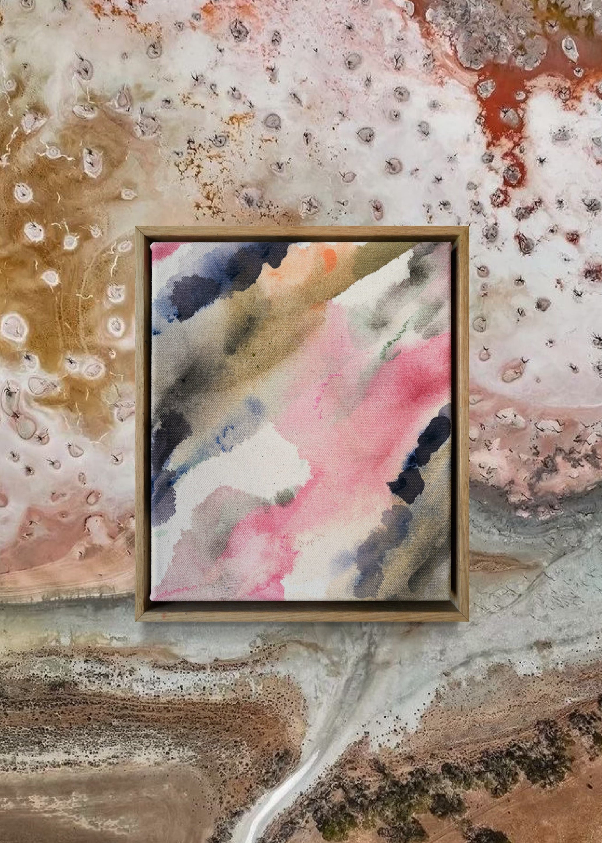 Abstract acrylic painting with pink, blue, and gray hues on raw canvas. Bordered by a wooden frame. Conveys a natural, ethereal mood.