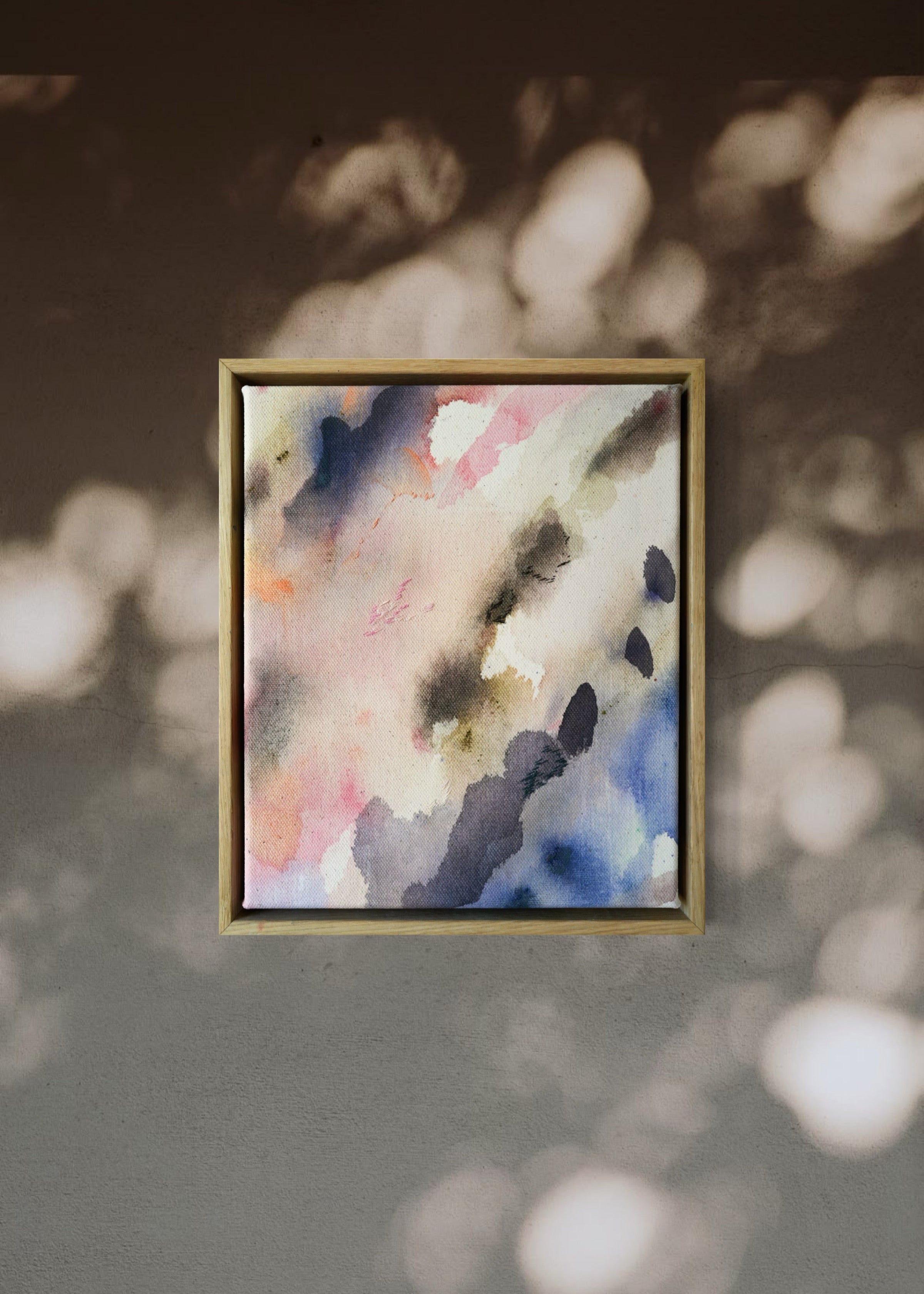 Abstract acrylic painting featuring soft, blended hues of pink, blue, and gray in flowing, harmonious patterns, framed in light wood. Radiates a subtle, tranquil tone perfect for creating a calming atmosphere.