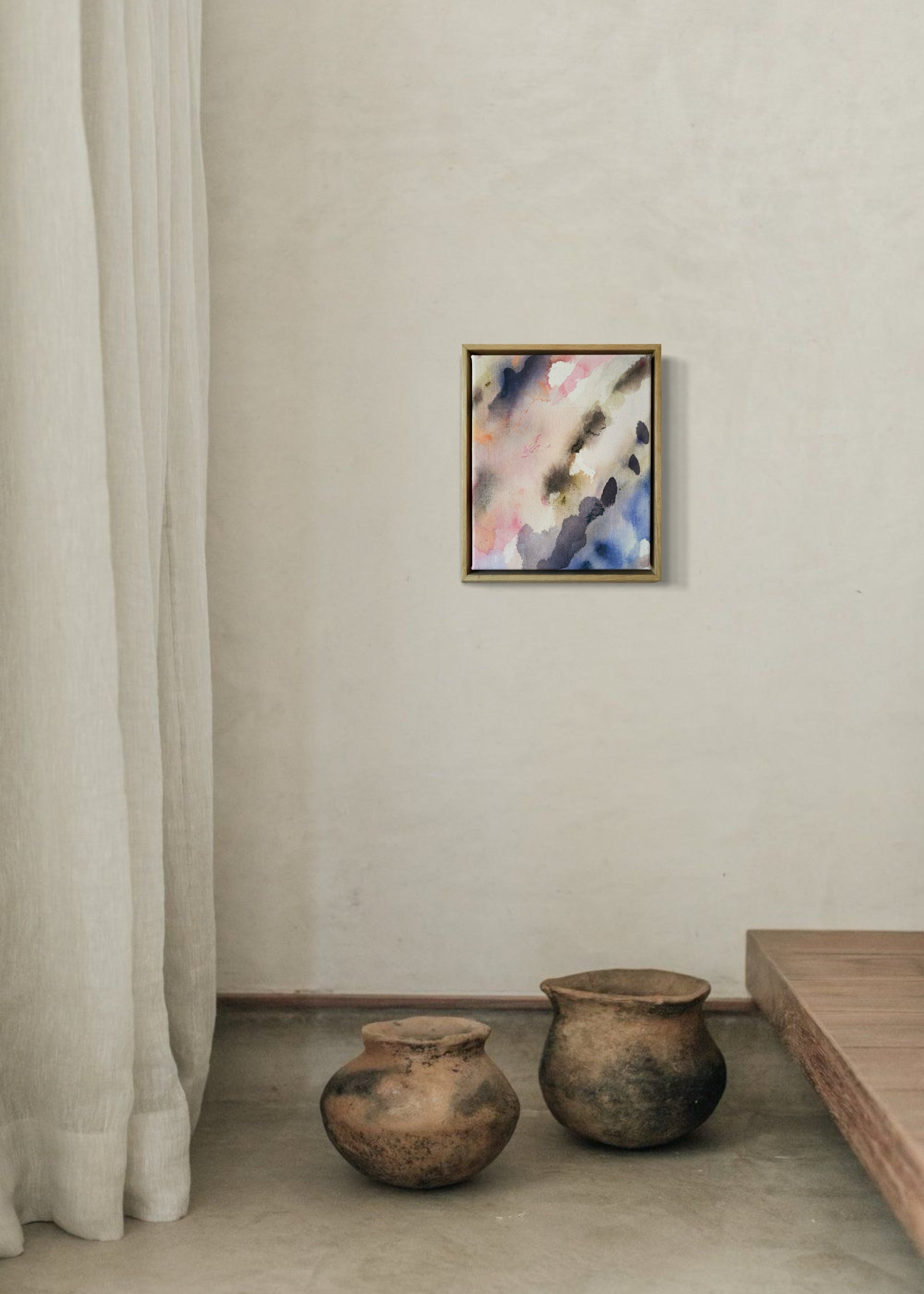 Abstract acrylic painting featuring soft, blended hues of pink, blue, and gray in flowing, harmonious patterns, framed in light wood. Radiates a subtle, tranquil tone perfect for creating a calming atmosphere.