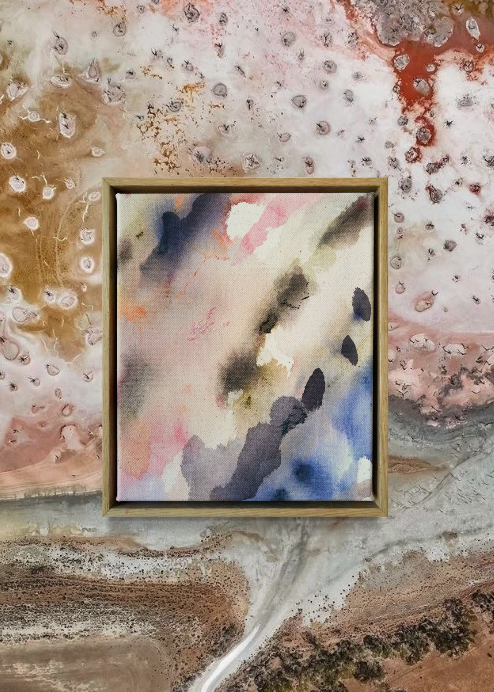Abstract acrylic painting featuring soft, blended hues of pink, blue, and gray in flowing, harmonious patterns, framed in light wood. Radiates a subtle, tranquil tone perfect for creating a calming atmosphere.