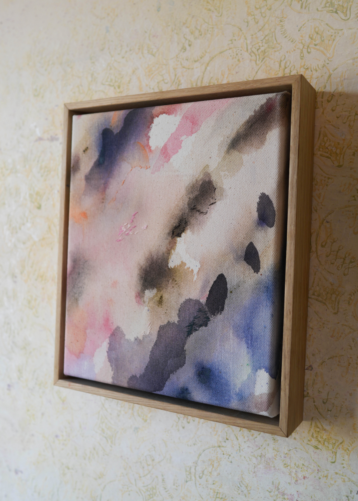Abstract acrylic painting featuring soft, blended hues of pink, blue, and gray in flowing, harmonious patterns, framed in light wood. Radiates a subtle, tranquil tone perfect for creating a calming atmosphere.