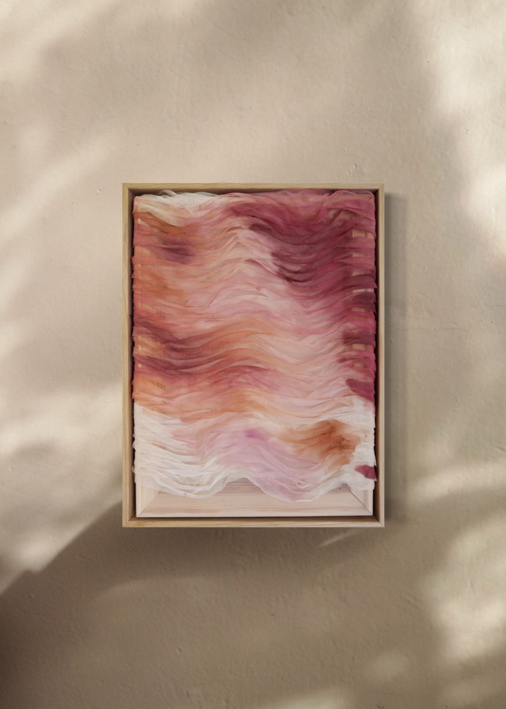 Abstract artwork featuring layered haute couture fabric from Carolina Herrera. Colors include light pink, red, orange, and deep red, arranged in wavy patterns.