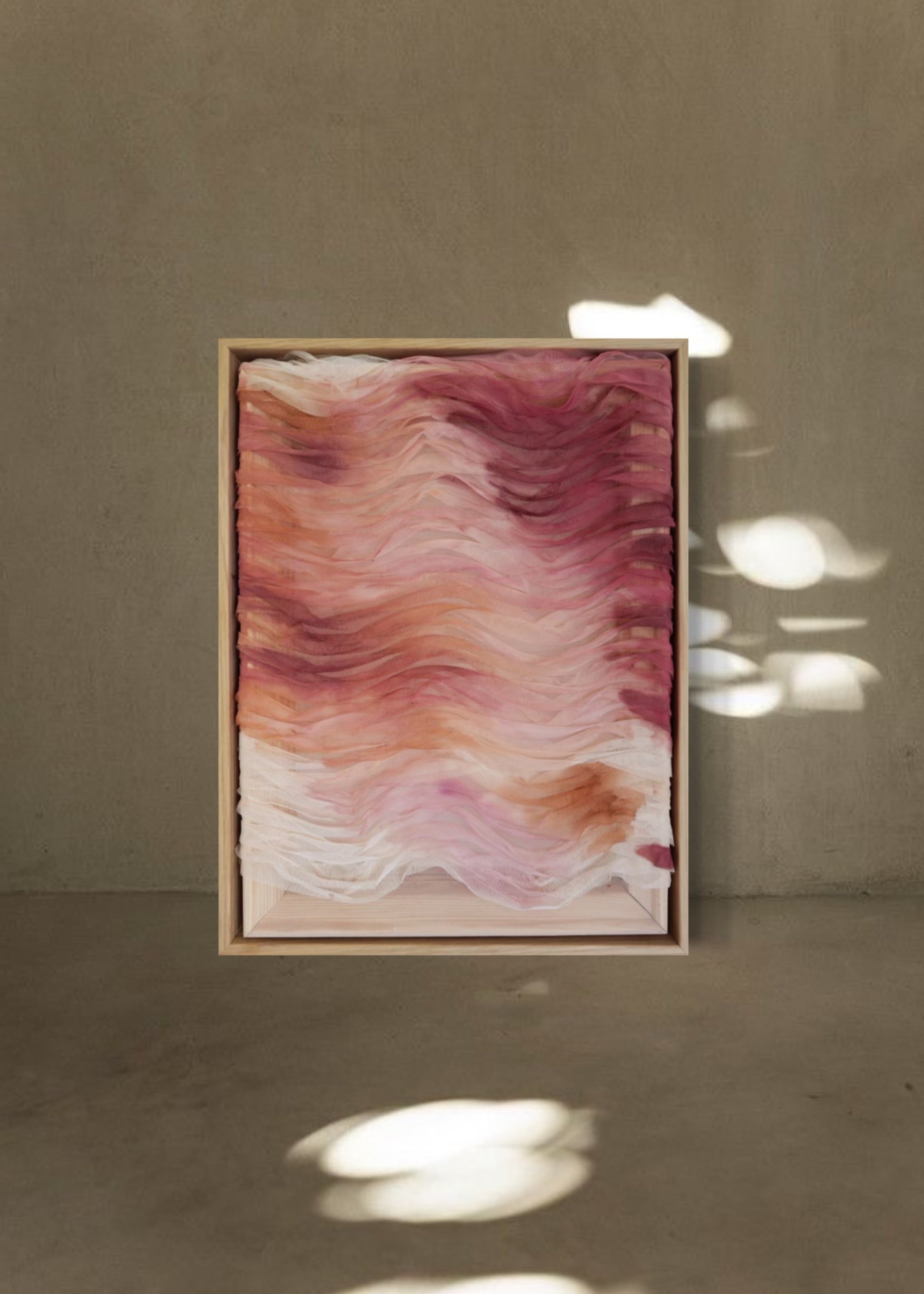 Abstract artwork featuring layered haute couture fabric from Carolina Herrera. Colors include light pink, red, orange, and deep red, arranged in wavy patterns.