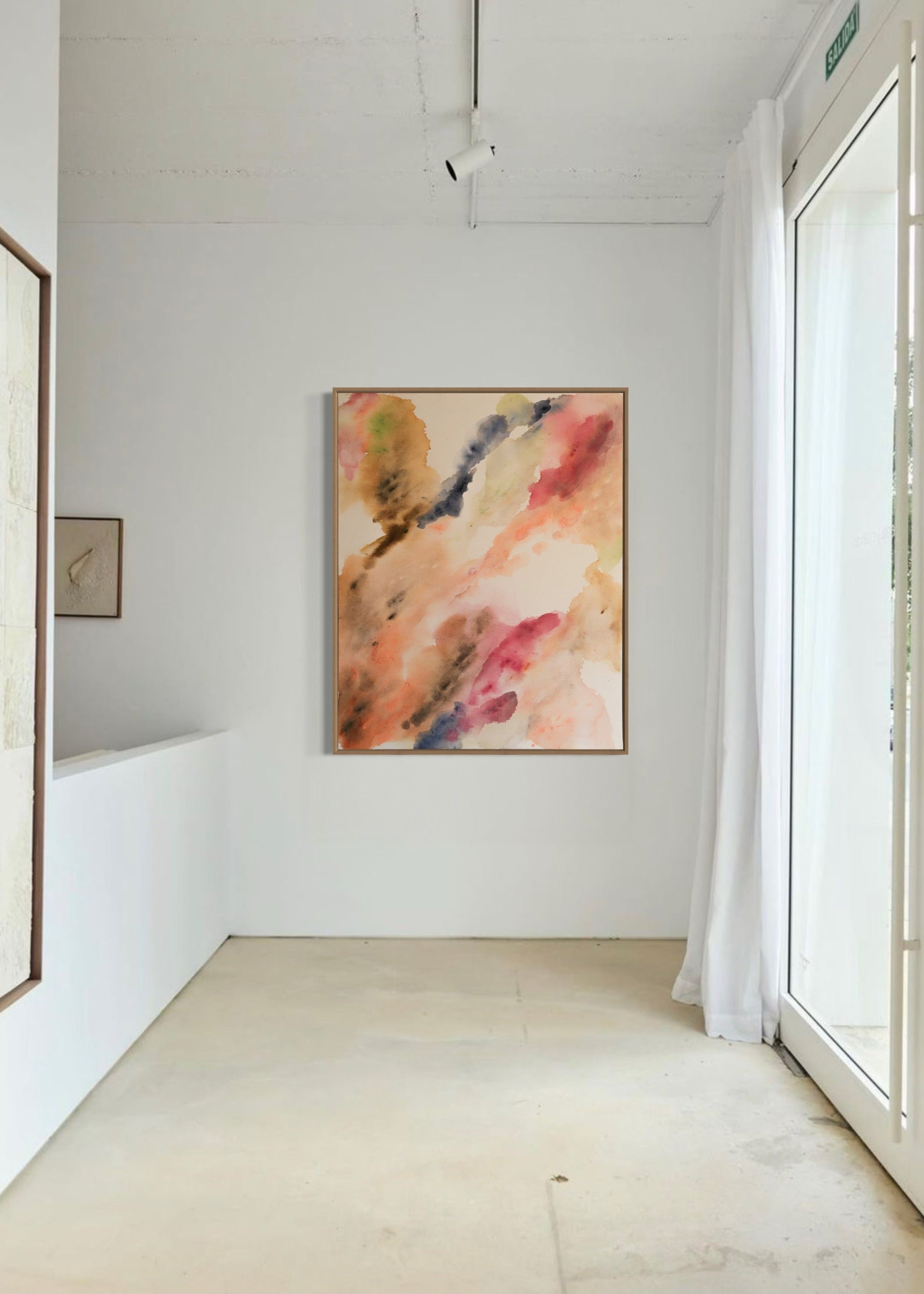Abstract watercolor in earthy tones such as beige, rose, orange, and brown, with touches of blue and green. The colors flow transparently into one another on a white background, framed in a slim, wooden frame.