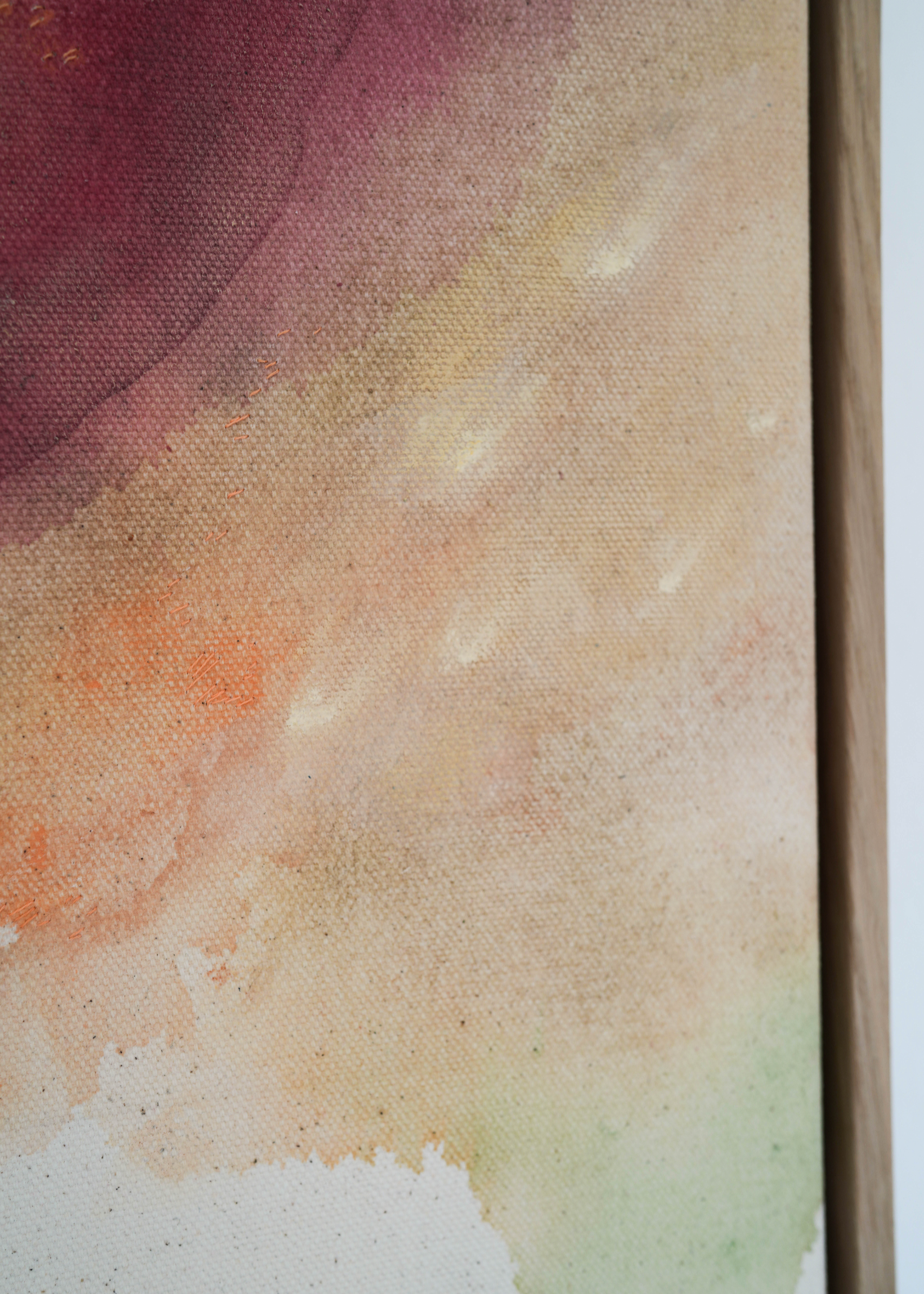 Abstract watercolor in earthy tones such as beige, rose, orange, and brown, with touches of blue and green. The colors flow transparently into one another on a white background, framed in a slim, wooden frame.