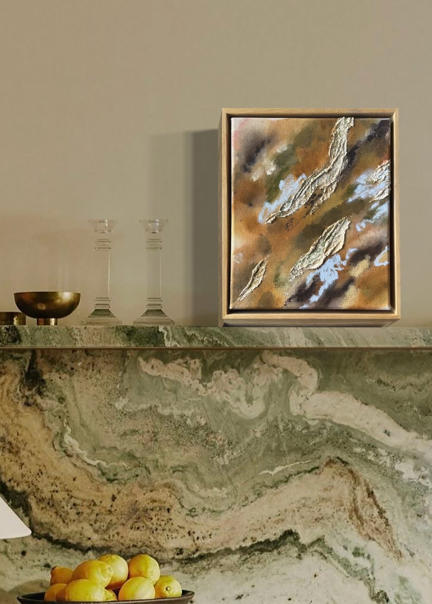 Abstract painting with textured, layered elements in shades of brown, green, and blue. The canvas features irregular shapes resembling organic forms. Framed in oak wood.