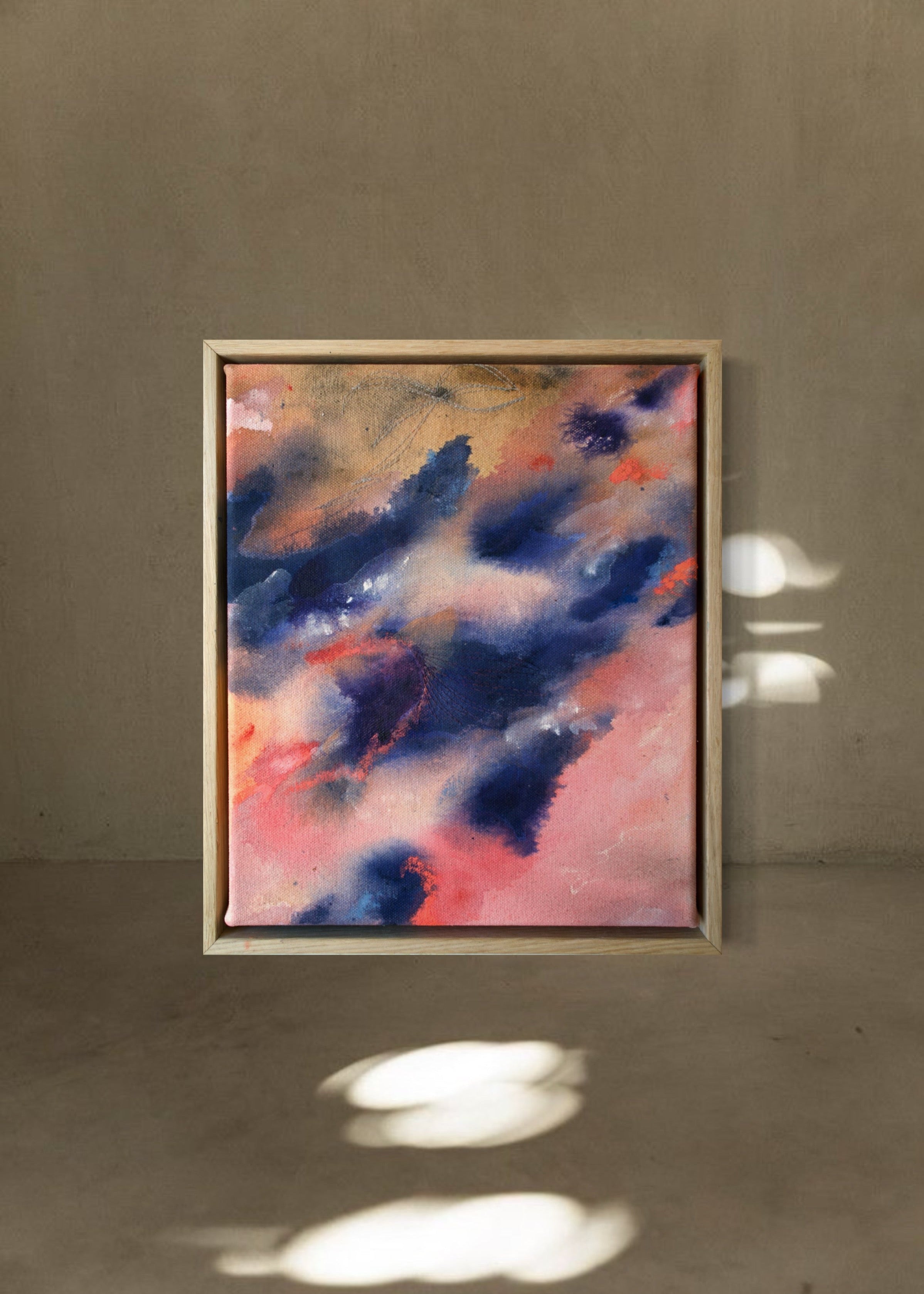 Abstract painting with swirling blue and pink tones, framed in wood, evoking motion and emotion.