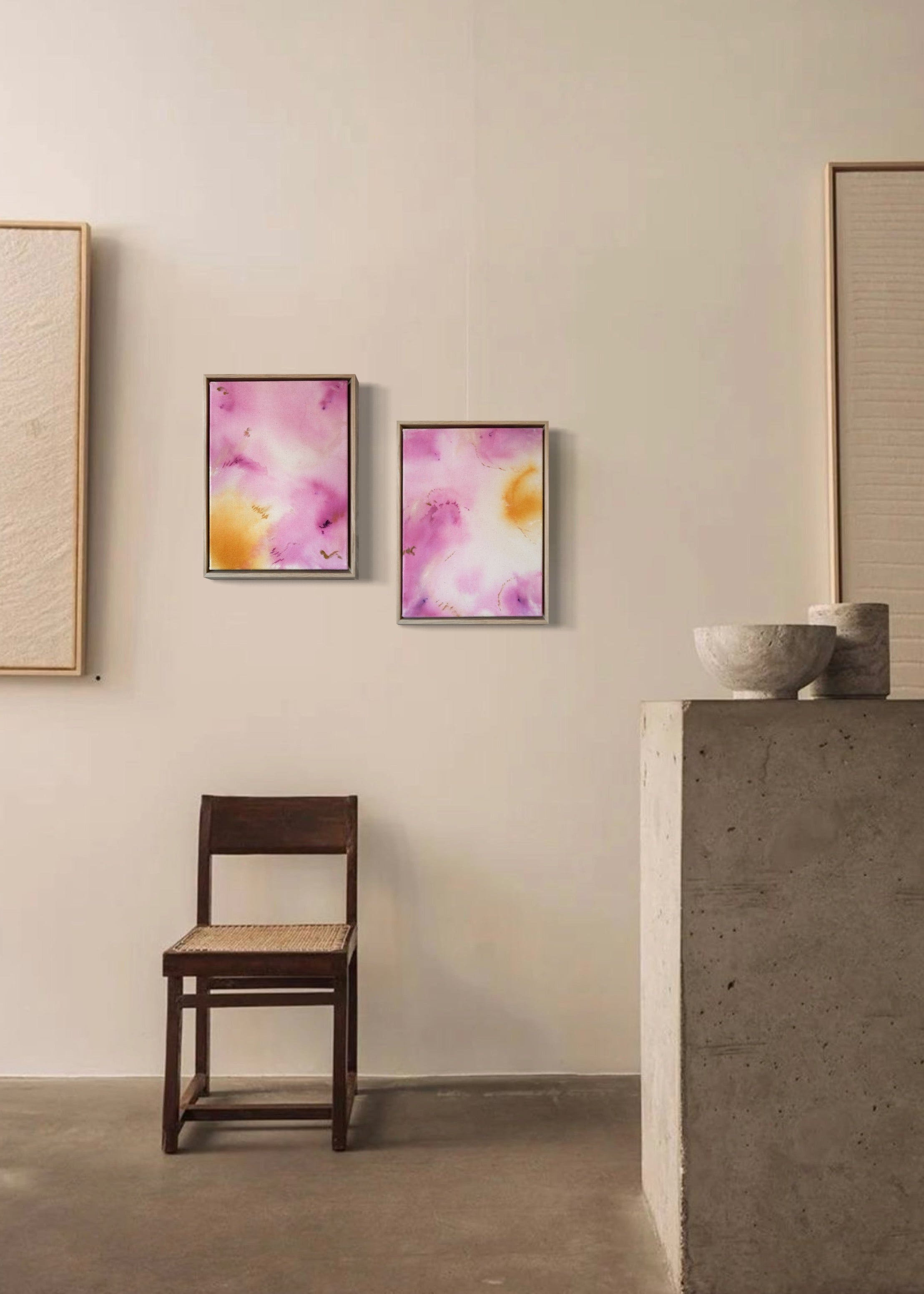 Abstract painting with soft pink, purple, and yellow tones blending across the canvas, accented by small embroideries in pink and yellow, framed in natural wood
