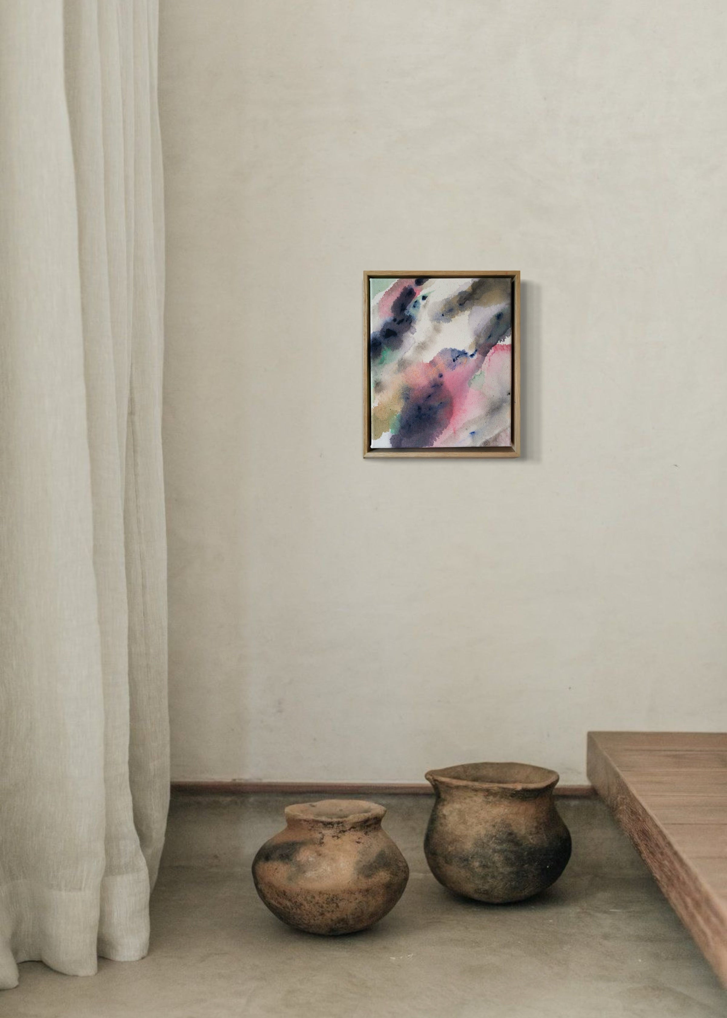 Abstract acrylic painting in a wooden frame displays blended swirls of pink, blue, and earthy tones on textured cotton canvas, evoking a serene mood.