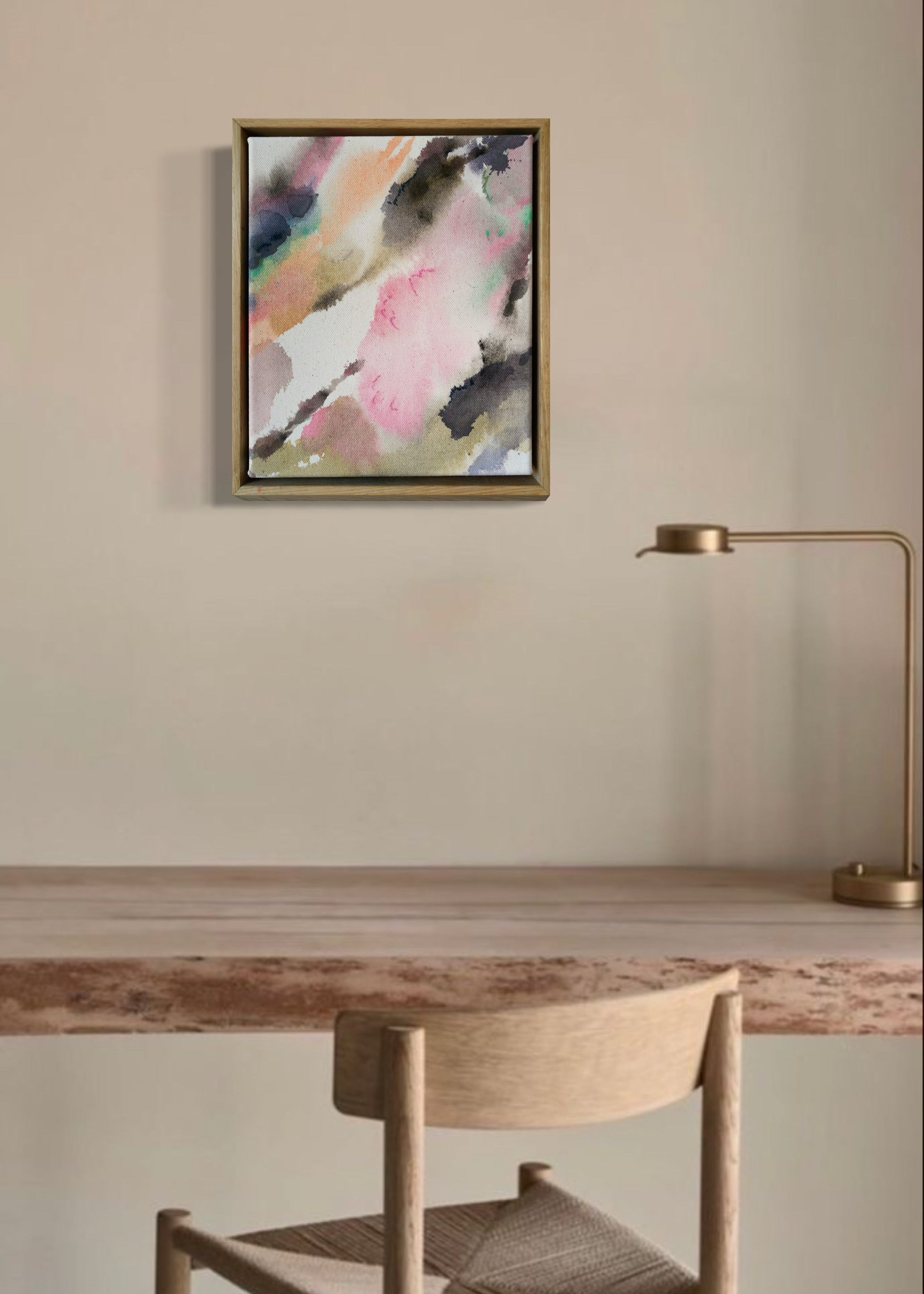 Abstract acrylic, fluid painting with soft pink, peach, green, and dark grey splashes, framed by light wood, conveying an impressionistic and soothing tone.
