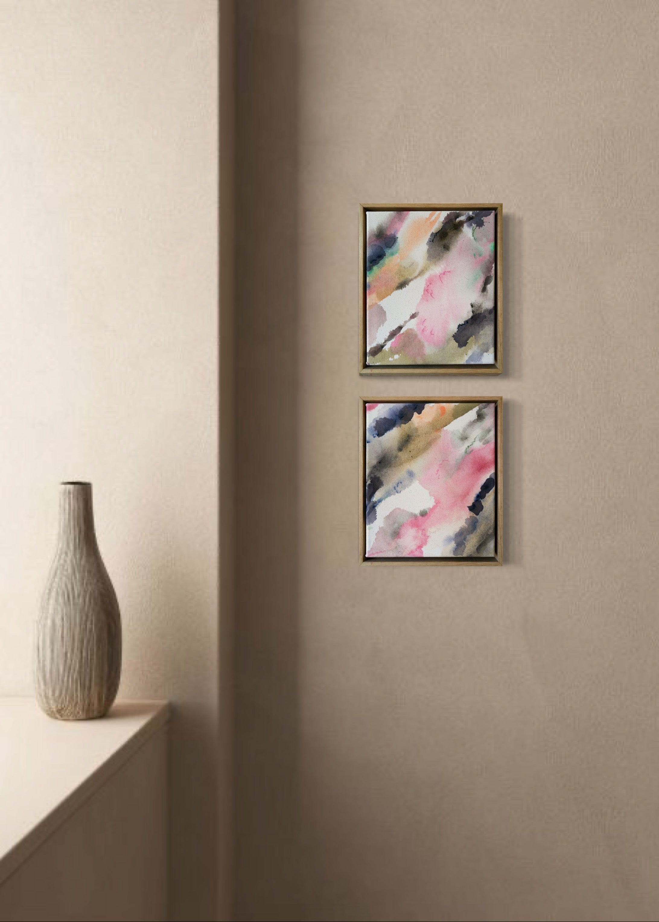 Abstract acrylic, fluid painting with soft pink, peach, green, and dark grey splashes, framed by light wood, conveying an impressionistic and soothing tone.