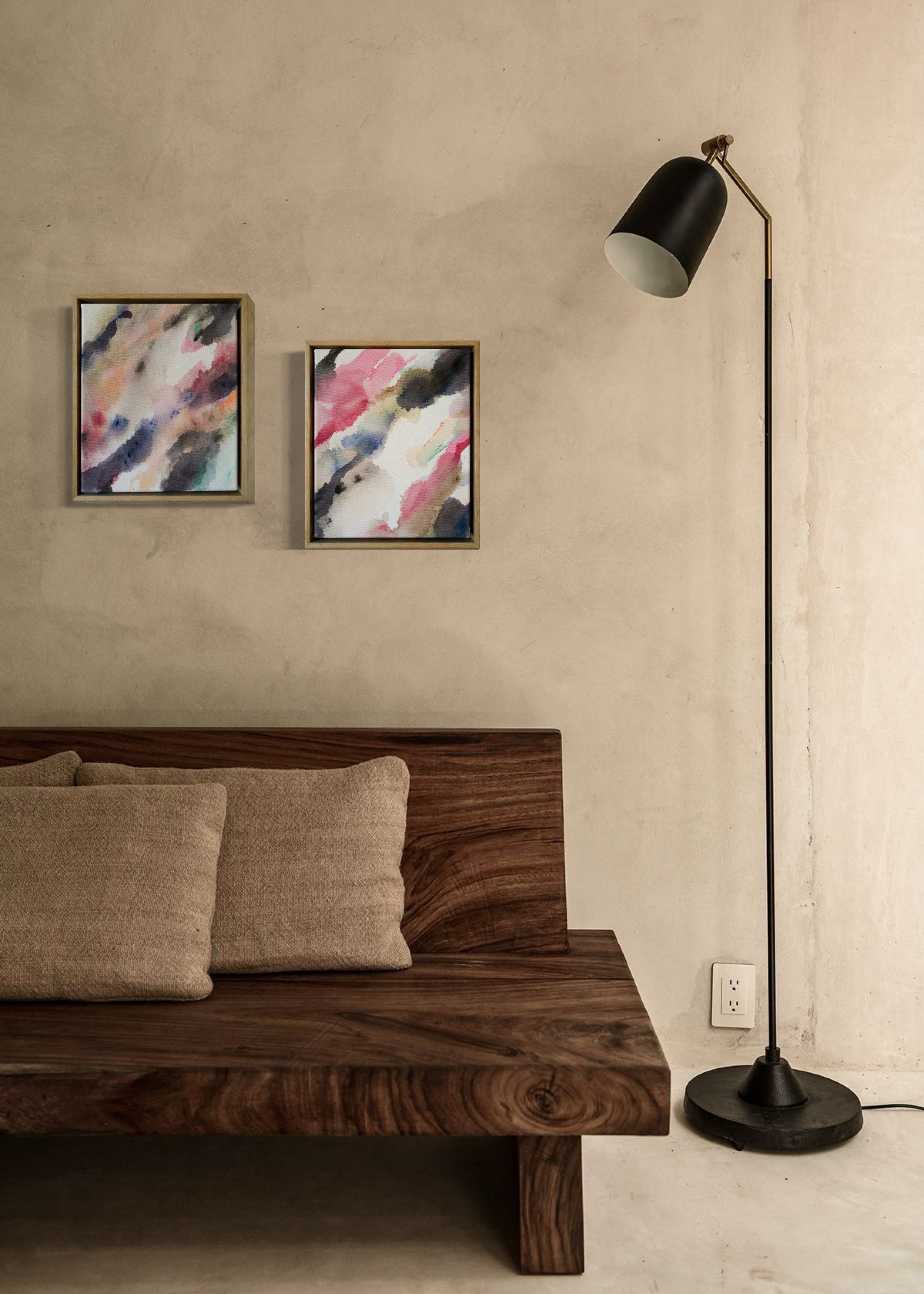 Abstract acrylic watercolor painting in a wooden frame. Soft pink, grey, and brown hues blend on a raw canvas, creating a calm, fluid effect.
