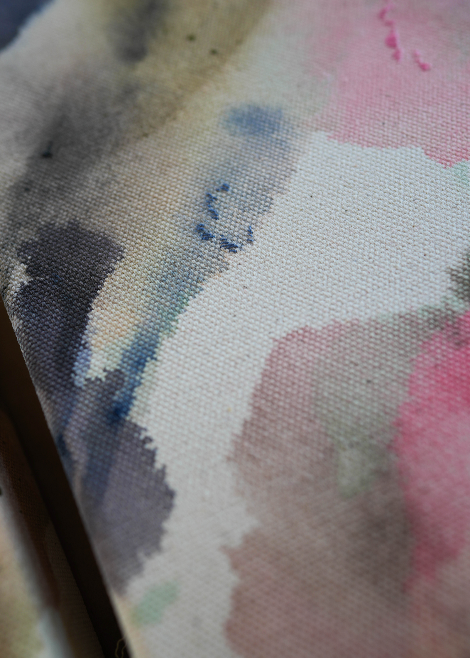 Abstract acrylic painting with pink, blue, and gray hues on raw canvas. Bordered by a wooden frame. Conveys a natural, ethereal mood.