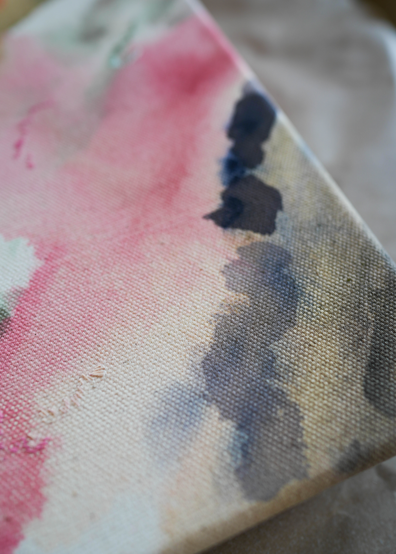 Abstract acrylic painting with pink, blue, and gray hues on raw canvas. Bordered by a wooden frame. Conveys a natural, ethereal mood.