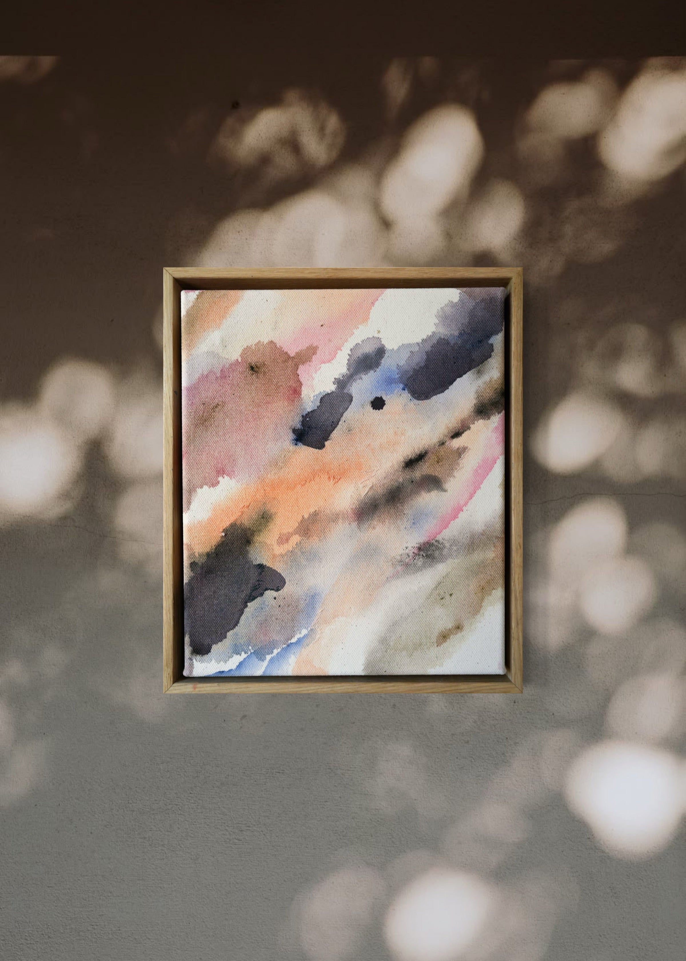 Abstract acrylic painting with soft, flowing shades of pink, peach, gray, and blue. Framed in light wood, the art conveys a calm, dreamy atmosphere.