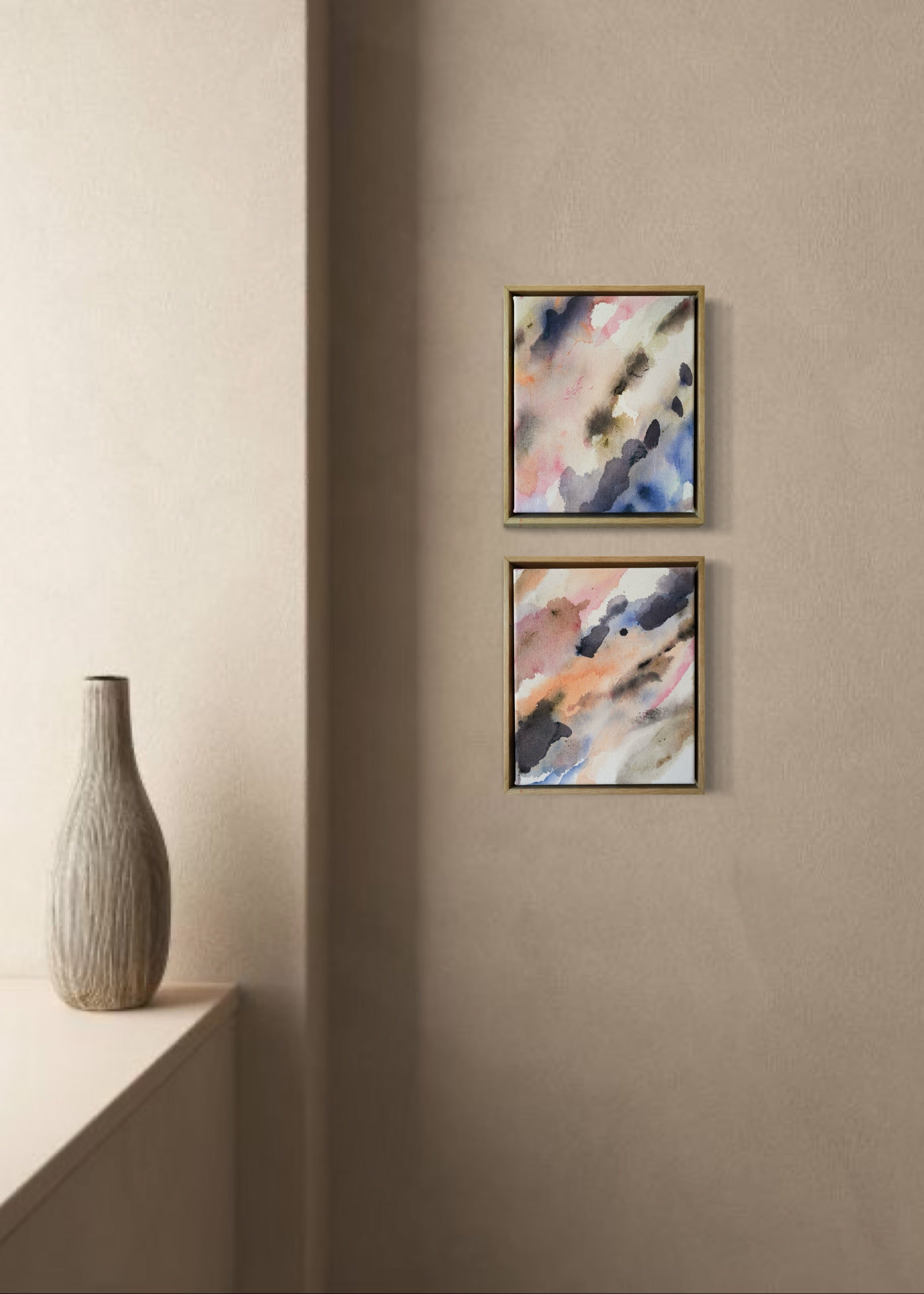 Abstract acrylic painting with soft, flowing shades of pink, peach, gray, and blue. Framed in light wood, the art conveys a calm, dreamy atmosphere.