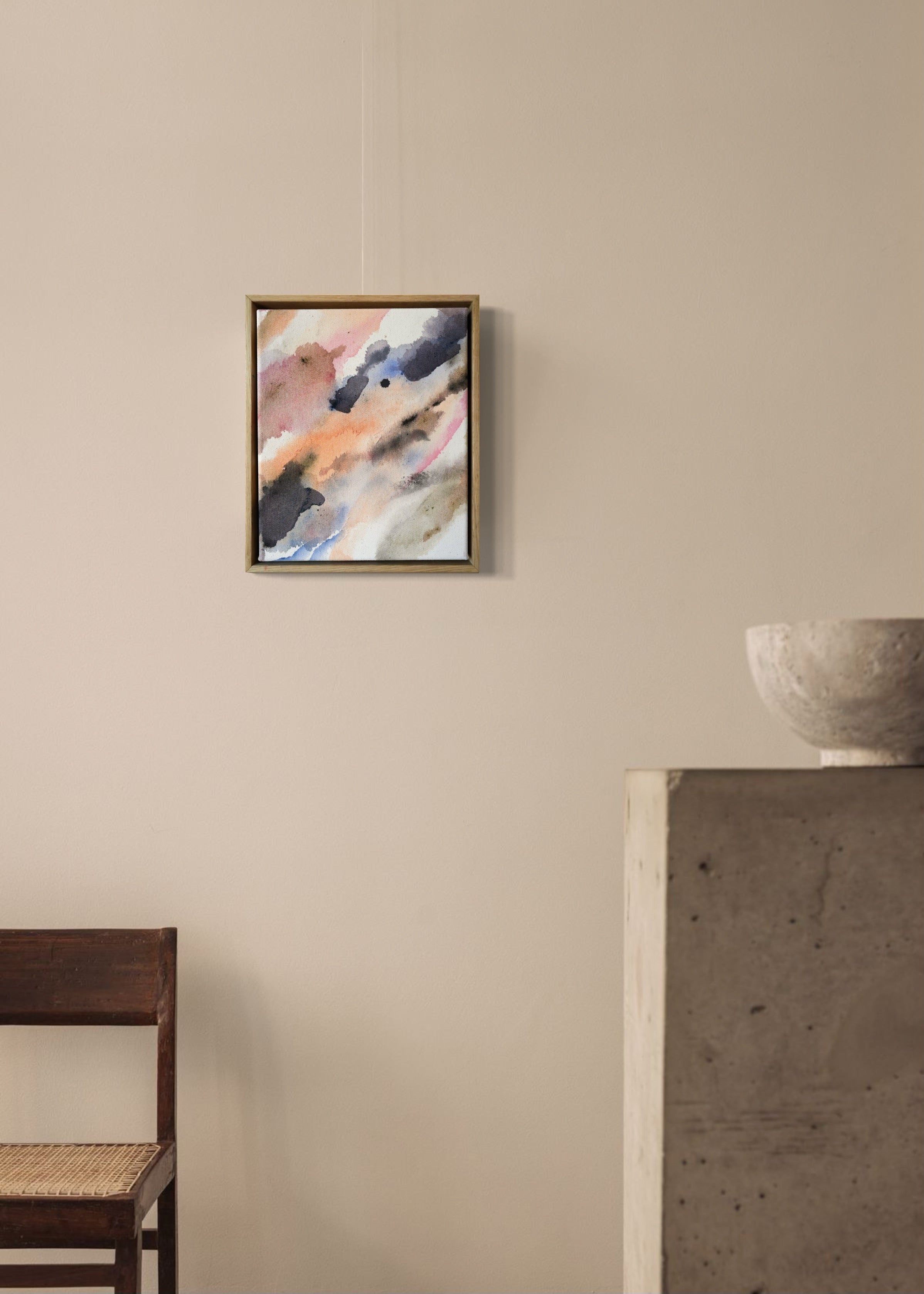 Abstract acrylic painting with soft, flowing shades of pink, peach, gray, and blue. Framed in light wood, the art conveys a calm, dreamy atmosphere.