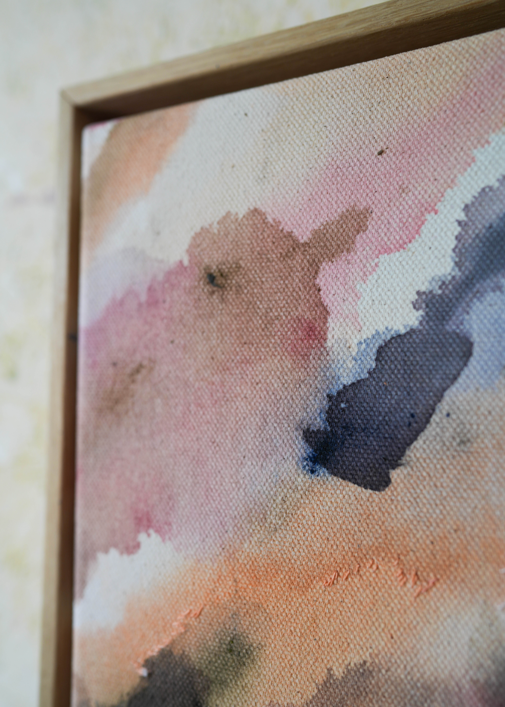 Abstract acrylic painting with soft, flowing shades of pink, peach, gray, and blue. Framed in light wood, the art conveys a calm, dreamy atmosphere.