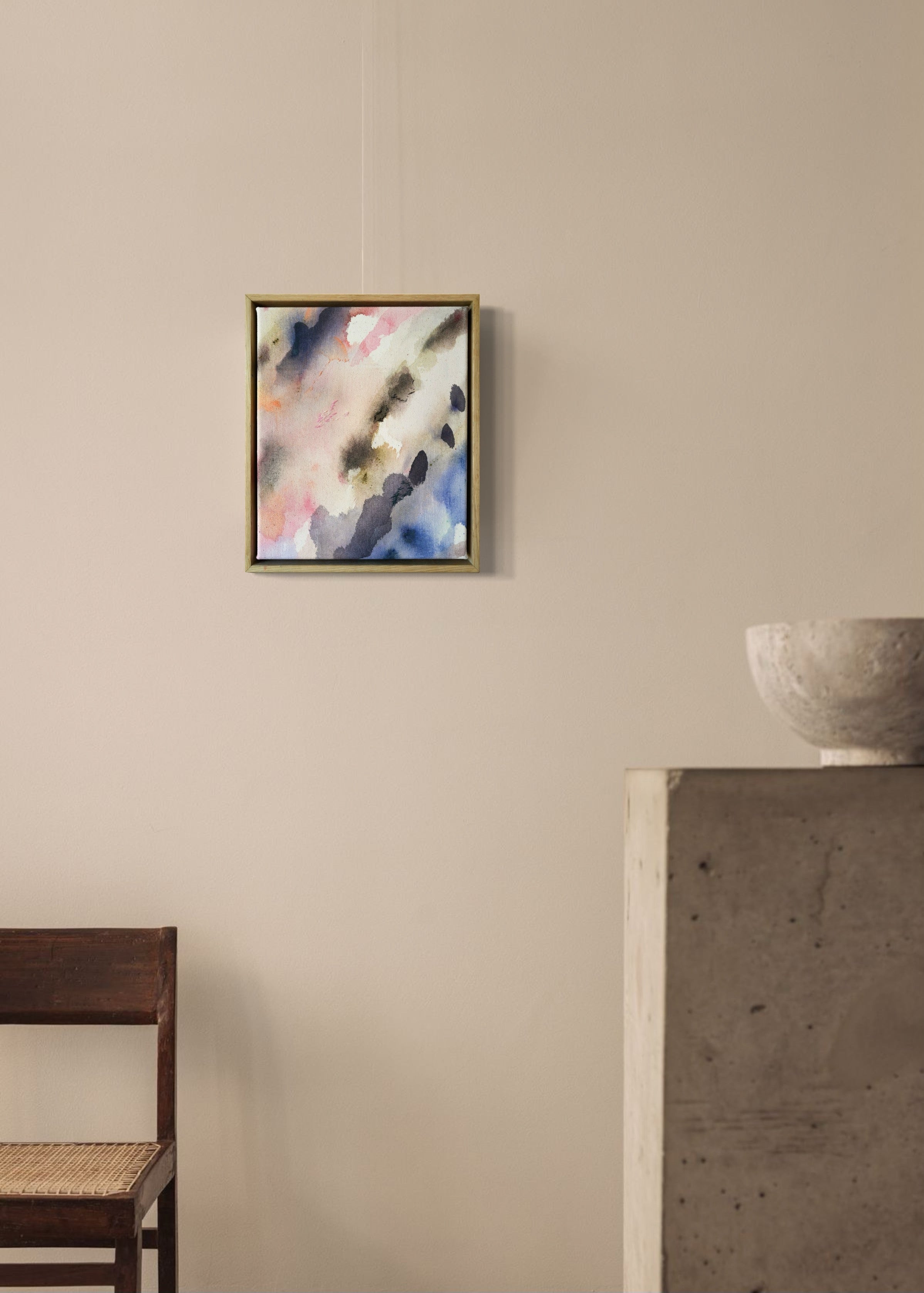 Abstract acrylic painting featuring soft, blended hues of pink, blue, and gray in flowing, harmonious patterns, framed in light wood. Radiates a subtle, tranquil tone perfect for creating a calming atmosphere.