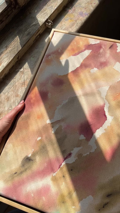 Abstract painting featuring soft, flowing shapes in shades of pink, beige, orange, and green shades, with a textured appearance  framed in oak wood.