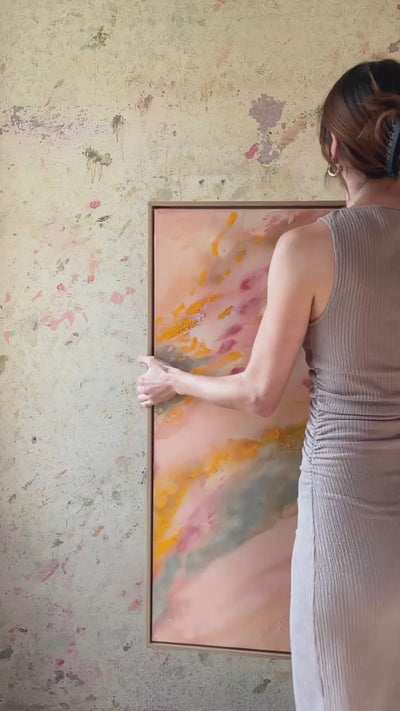 Abstrakt artwork featuring swirling patterns in pink, orange, and pastel tones in green and orange on a textured surface framed in oak wood.