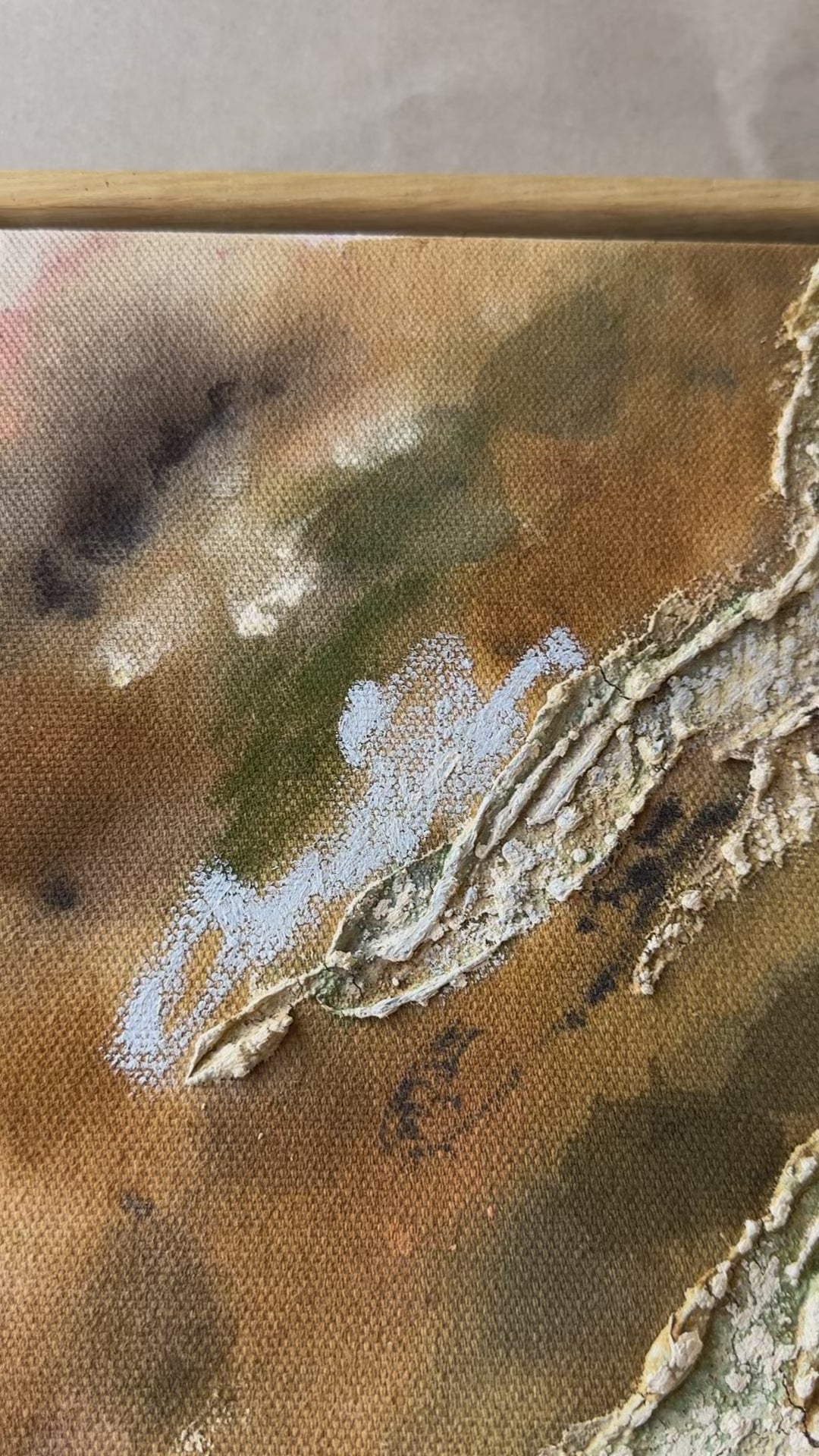 Abstract painting with textured, layered elements in shades of brown, green, and blue. The canvas features irregular shapes resembling organic forms. Framed in oak wood.