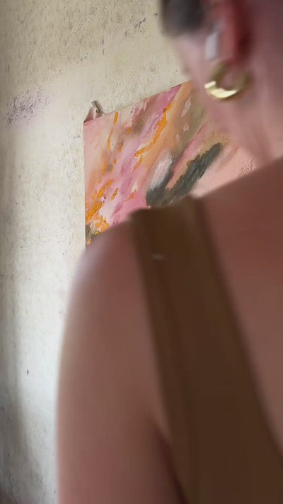 Abstrakt artwork featuring swirling patterns in pink, orange, and pastel tones in green and orange on a textured surface framed in oak wood.